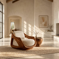 Lounge chair with a sculpted wooden shell and cream seat cushion in a bright open plan living room