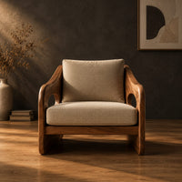 Lounge chair with oval side cutouts and tan cushions in a dark studio against a charcoal plaster wall