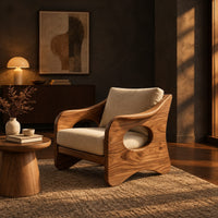 Lounge chair with oval side cutouts and tan cushions in a dark living room at golden hour