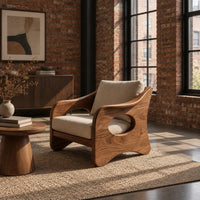 Lounge chair with oval side cutouts and tan cushions in an industrial loft living room with exposed brick