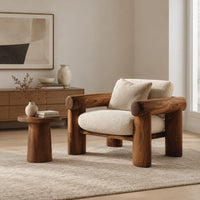 Lounge chair with thick log style arms, post legs and cream cushions in a Scandinavian living room with white walls