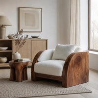Lounge chair with wide solid wood arm panels and a cushioned seat in a Scandinavian living room with white walls