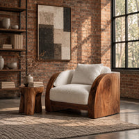 Lounge chair with wide solid wood arm panels and a cushioned seat in an industrial loft living room with exposed brick
