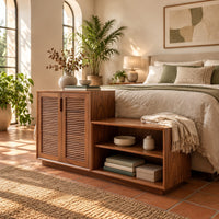 Stepped low cabinet with two louvered doors and an open shelf section in a bright bedroom with arched windows and plants
