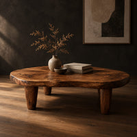 Low bean shaped coffee table with a rich grained top and four tapered legs, three-quarter view showing the grain