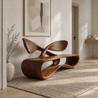 Low wooden bench with a looping oval body and a crossed ribbon backrest in a Scandinavian entryway with white walls