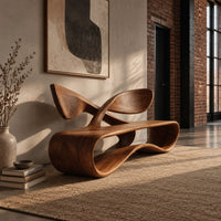 Low wooden bench with a looping oval body and a crossed ribbon backrest in an industrial loft entryway with exposed brick