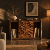 Low bookshelf with two carved wave doors and open bays at both ends in a dark living room at golden hour
