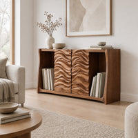 Low bookshelf with two carved wave doors and open bays at both ends in a Scandinavian living room with white walls