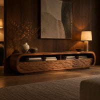 Low capsule shaped tv stand with wave carved fronts and open bays in an evening living room with walnut wall paneling
