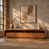 Low capsule shaped tv stand with wave carved fronts and open bays in an industrial loft living room with exposed brick