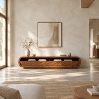 Low capsule shaped tv stand with wave carved fronts and open bays in a bright open plan living room