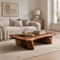 Low coffee table with a thick slab top and two boat shaped legs in a Scandinavian living room with white walls