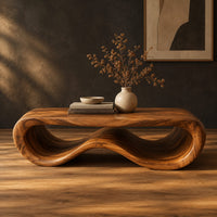 Low oval wooden coffee table with a folded ribbon body in a dark studio against a charcoal plaster wall