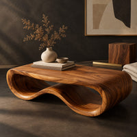 Corner detail of low oval wooden coffee table with a folded ribbon body beside wood, brass and linen samples