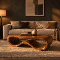 Low oval wooden coffee table with a folded ribbon body in a dark living room at golden hour
