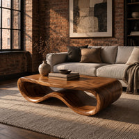 Low oval wooden coffee table with a folded ribbon body in an industrial loft living room with exposed brick
