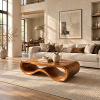 Low oval wooden coffee table with a folded ribbon body in a bright open plan living room