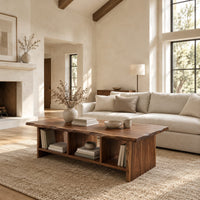 Low coffee table with a wavy natural edge top and three open cubbies in a bright open plan living room
