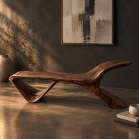 Low wooden bench with a swept up end and an open triangle leg, three-quarter view showing the grain