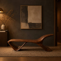 Low wooden bench with a swept up end and an open triangle leg in a dark entryway at golden hour