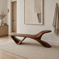 Low wooden bench with a swept up end and an open triangle leg in a Scandinavian entryway with white walls