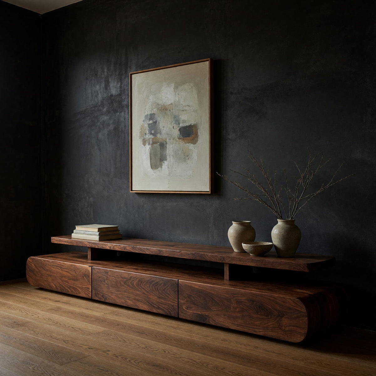 Low drawer plinth TV stand with a floating shelf in a dark studio against a charcoal wall