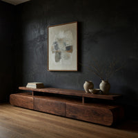 Low drawer plinth TV stand with a floating shelf in a dark studio against a charcoal wall