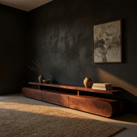 Low drawer plinth TV stand with a floating shelf in a living room at golden hour