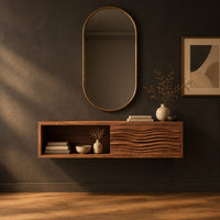 Floating makeup vanity with an open cubby and a wave carved front panel in a dark studio against a charcoal plaster wall