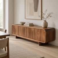 Low wood sideboard with four flat front panels and short legs in a Scandinavian dining room with white walls