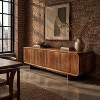Low wood sideboard with four flat front panels and short legs in an industrial loft dining room with exposed brick