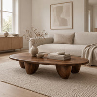 Low oval coffee table with a thick top and chunky pod shaped legs in a Scandinavian living room with white walls