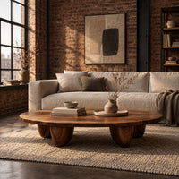Low oval coffee table with a thick top and chunky pod shaped legs in an industrial loft living room with exposed brick