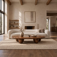 Low oval coffee table with a thick top and chunky pod shaped legs in a bright open plan living room