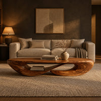 Low oval coffee table on a twisted open loop base in a dark living room at golden hour