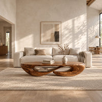 Low oval coffee table on a twisted open loop base in a bright open plan living room