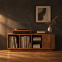 Low wood record console with three open cubbies and a panel end in a dark studio against a charcoal plaster wall