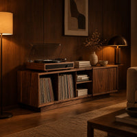 Low wood record console with three open cubbies and a panel end in an evening living room with walnut wall paneling