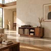 Low wood record console with three open cubbies and a panel end in a bright open plan living room
