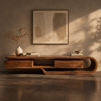 Corner detail of low tv stand shaped like a looping wood ribbon with two boxed front sections beside wood, brass and linen samples