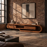 Low tv stand shaped like a looping wood ribbon with two boxed front sections in an industrial loft living room with exposed brick