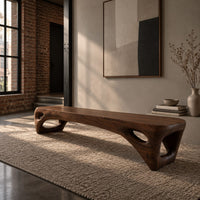 Low slab top bench with open triangular legs in an industrial loft entryway with exposed brick