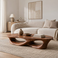Low coffee table with an oval top and twin open loops in a Scandinavian living room with white walls