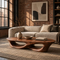 Low coffee table with an oval top and twin open loops in an industrial loft living room with exposed brick