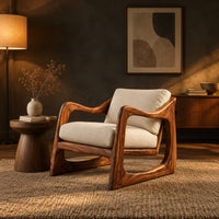 Low lounge chair with looped side frames, sloped arms and cream cushions in a dark living room at golden hour