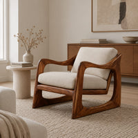 Low lounge chair with looped side frames, sloped arms and cream cushions in a Scandinavian living room with white walls