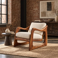 Low lounge chair with looped side frames, sloped arms and cream cushions in an industrial loft living room with exposed brick