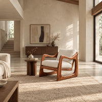 Low lounge chair with looped side frames, sloped arms and cream cushions in a bright open plan living room