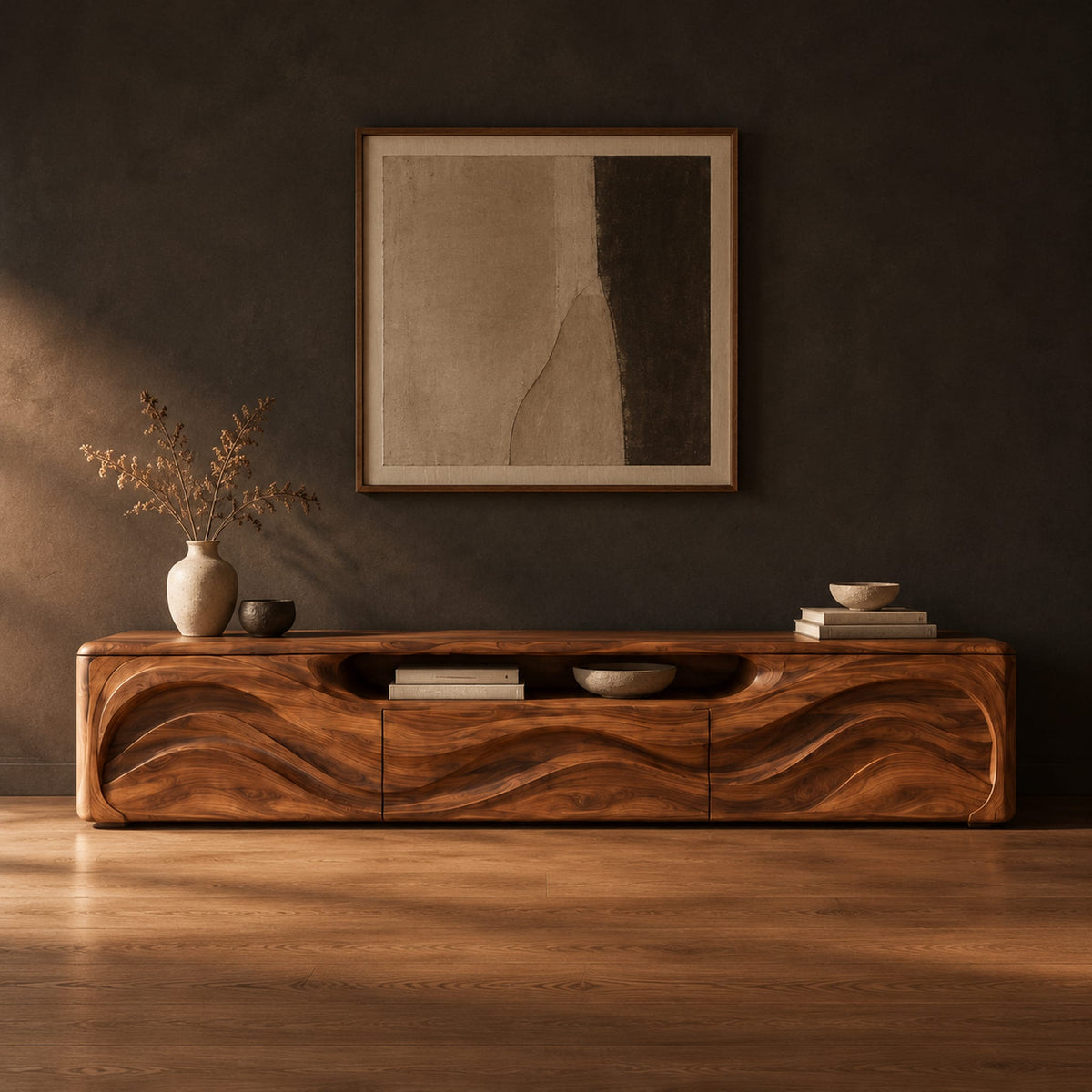 Low wood tv stand with a rippling carved front and an open top slot in a dark studio against a charcoal plaster wall